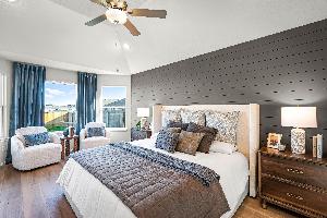 Primary bedroom in the model home located in Carillon at 13305 Eppright Trace Blvd., Manor, TX 