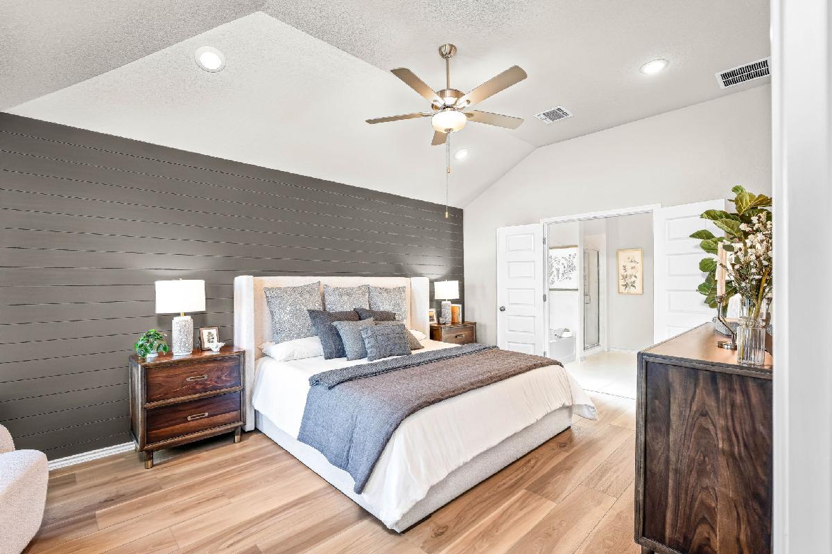 Primary bedroom in the model home located in Carillon at 13305 Eppright Trace Blvd., Manor, TX 