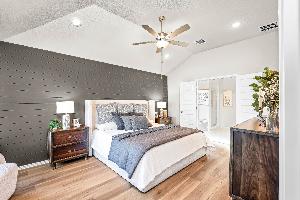 Primary bedroom in the model home located in Carillon at 13305 Eppright Trace Blvd., Manor, TX 